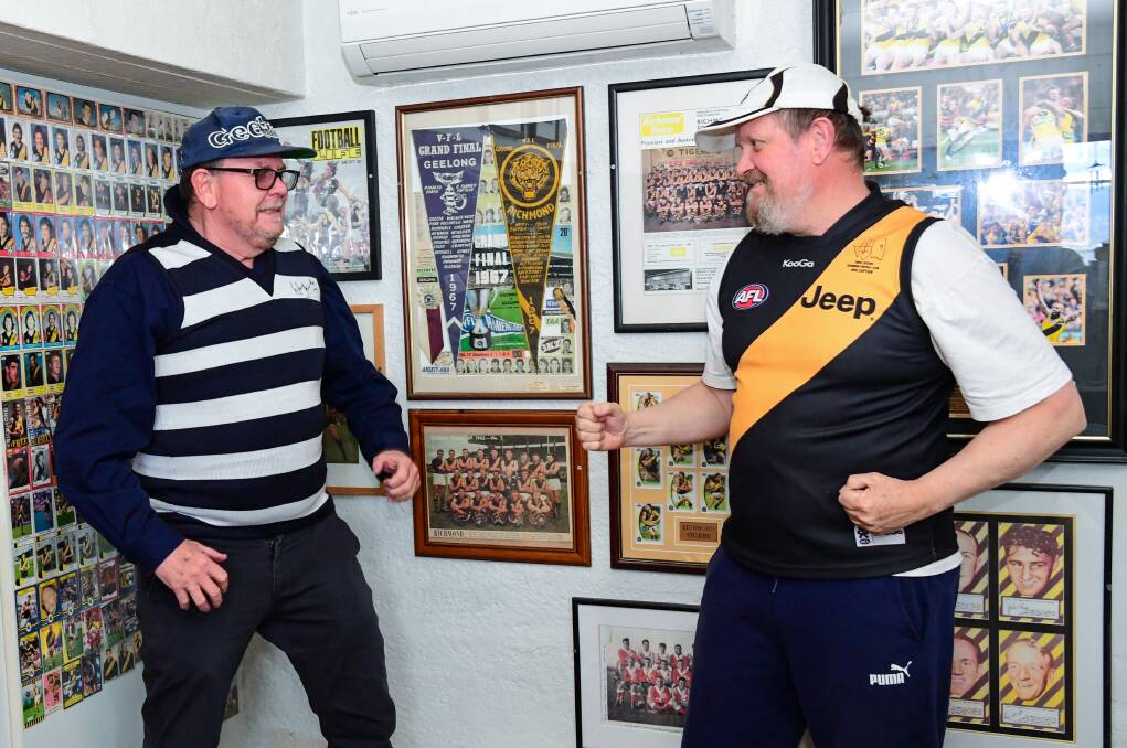 Brothers grim: Bill and Peter Walker in Peter's Tiger cave. Between them are pennants from the 1967 VFL Grand Final. Picture: Neil Richardson