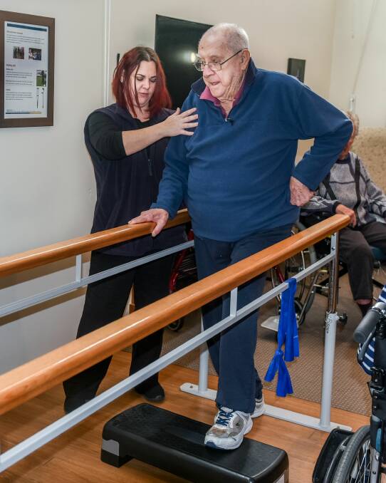 Occupational therapist Lisa Shearing assists Regis Aged Care resident Sam Musumeci, 88, with his mobility. Picture: Neil Richardson