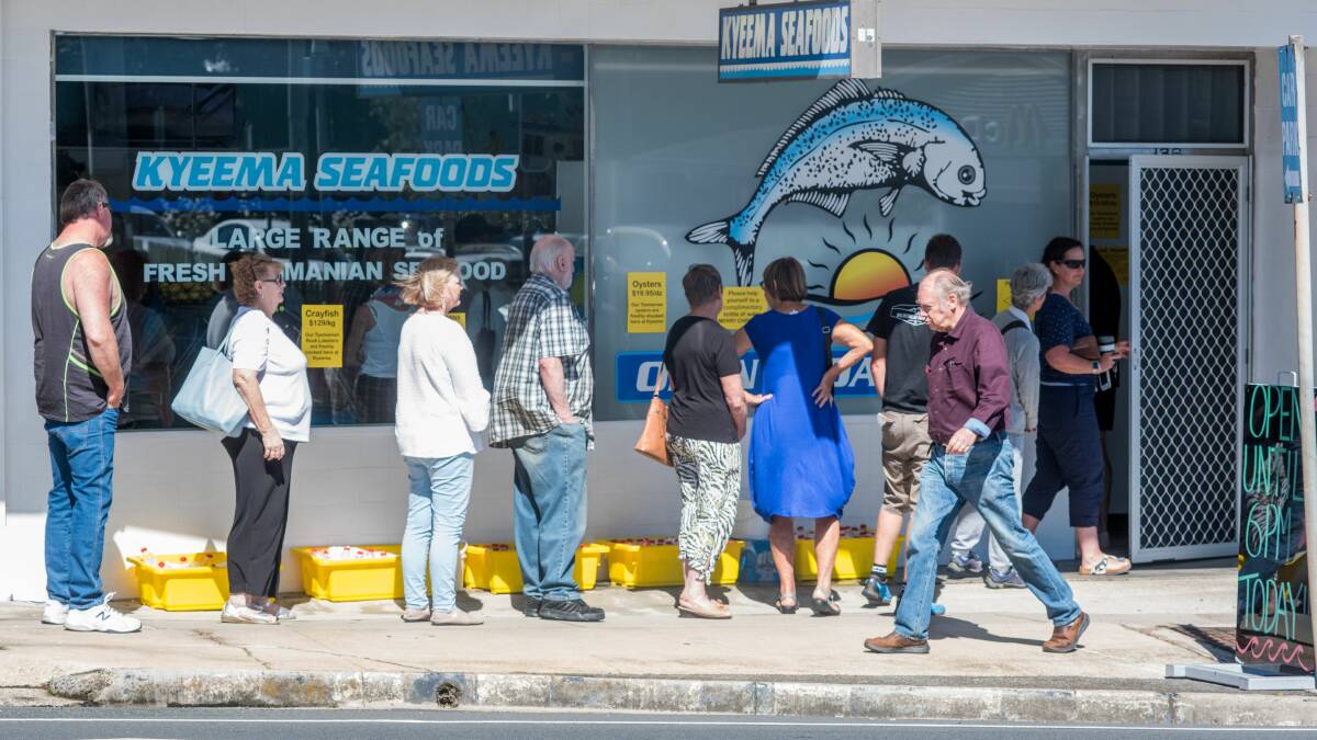 Customers line up for seafood outside Kyeema Seafoods at Kings Meadows. Free water was supplied for those waiting. Neil Richardson