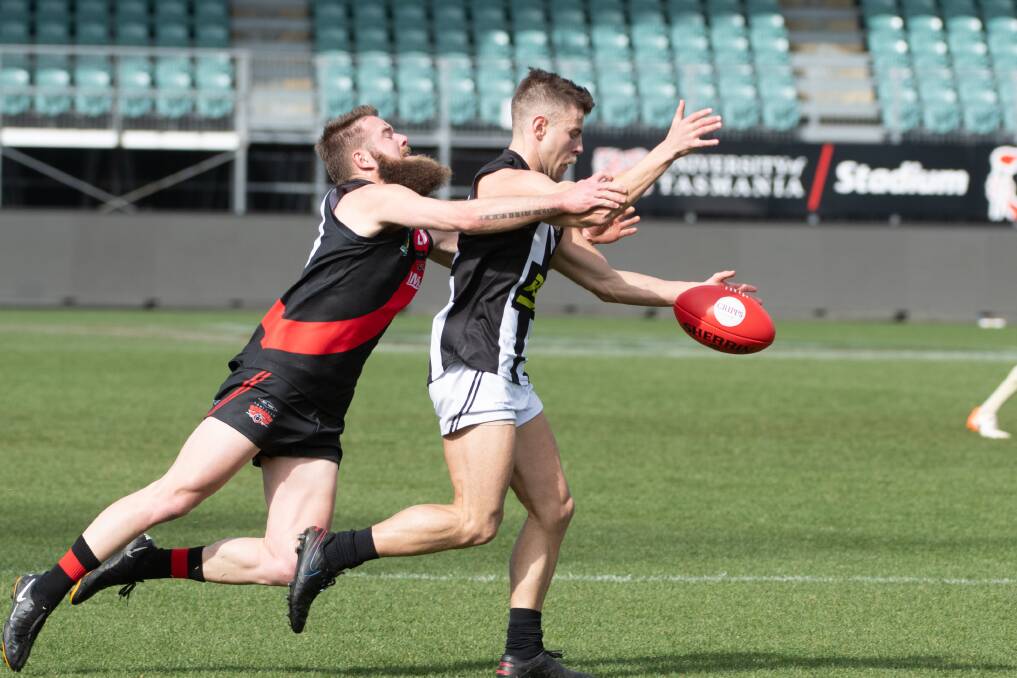 PIE DOWN: North's Nathan Pearce tackles Glenorchy's Nick Reibelt before he kicks. Picture: Paul Scambler