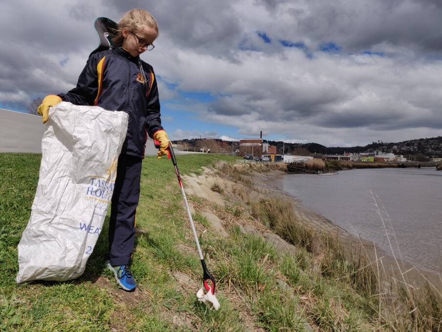 Clean effort: 11-year-old Maddie Hassell collecting rubbish along the North Esk River during a community cleaning effort. Picture: Harry Murtough