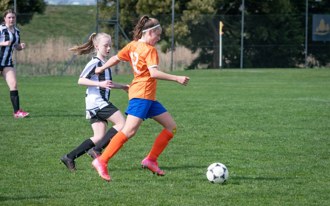 Launceston City Devils' Olivia Clark watches on as Riverside Diamonds' Imogen Donoghue plays a pass during their game.
