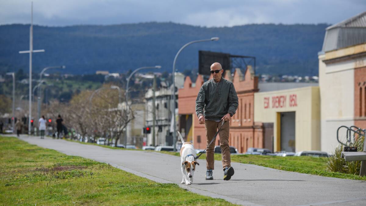 11:02:46: Geoff Clark walks his dog Rosie along the levee bank path beside the Esplanade, Launceston.