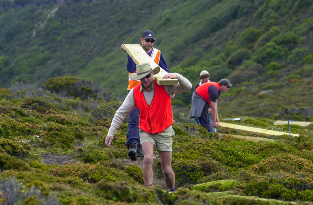 Wesley 'Joe' Jordan of Westbury and Shane Burdon of Devonport carry the planks to the boardwalk area from helicopter drop site in Cradle Mt