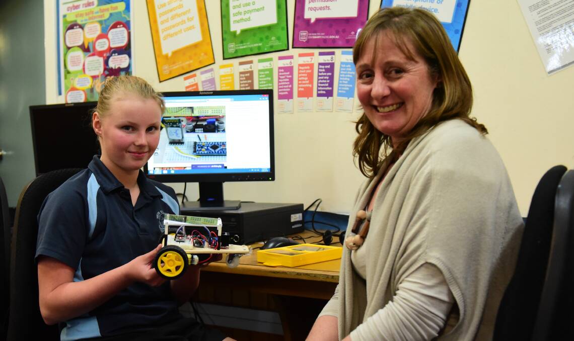 PROUD: Grade 5 student, Delaney Torlop, with her robot vehicle and The Peter Underwood Centre for Educational Attainment Community education Development Officer  Marcel Kerrison. Picture: WILL RYAN
