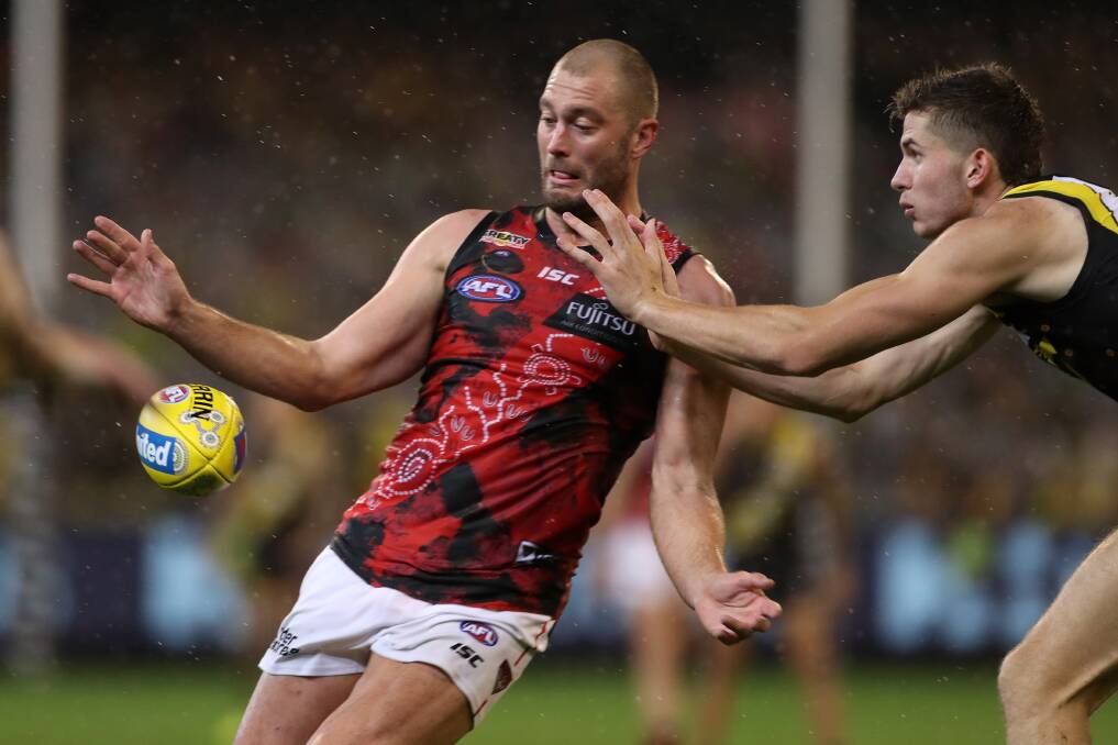 BIG NIGHT: Thomas Bellchambers gets his kick away in Essendon's loss to Richmond on Saturday. Picture: AAP Image/Mark Dadswell