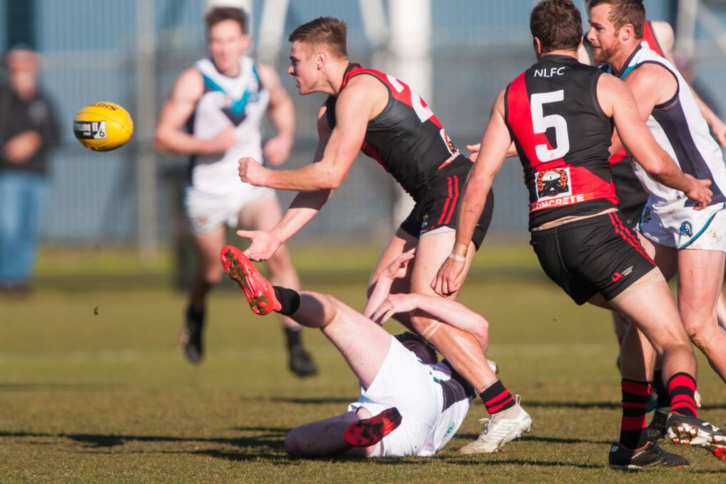  TOUGH GAME: Jay Foon gets a handball away during North Launceston's win over Devonport on Sunday.
