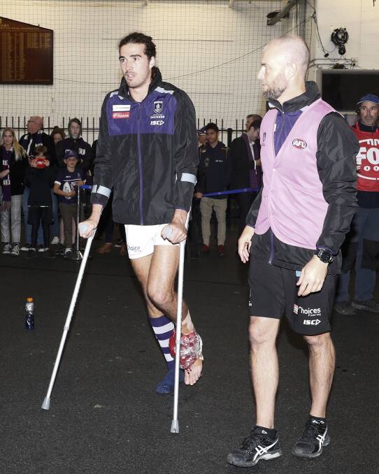 Alex Pearce on crutches in the rooms after the win over Collingwood. Picture: AAP Image/Daniel Pockett
