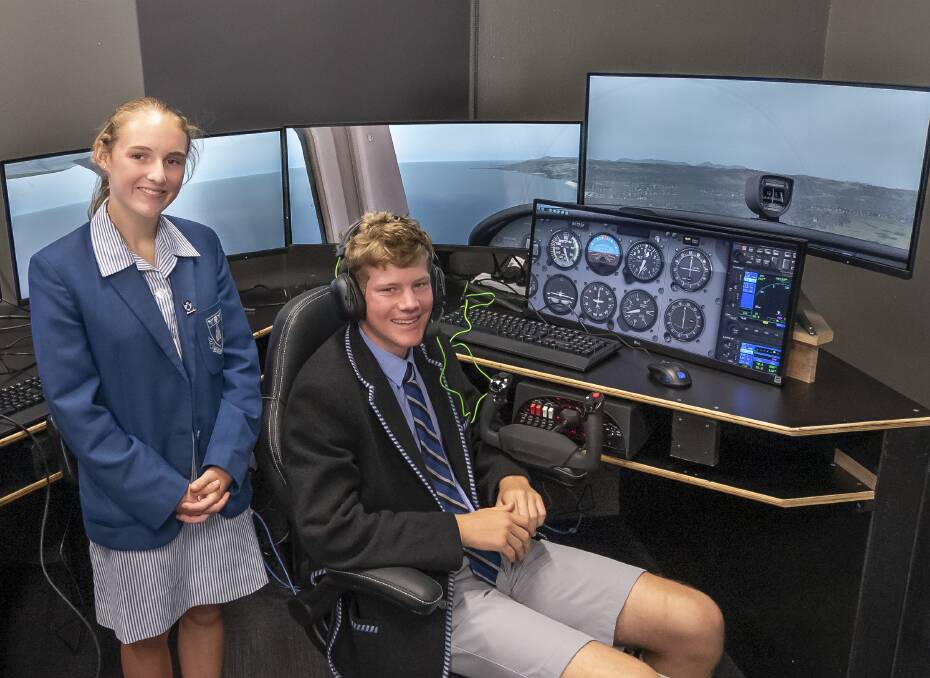 TAKE OFF: Grade 10 students Sophie Best,15, and Felix James,15, with one of the flight simulators in the new aviation centre. Picture: Craig George