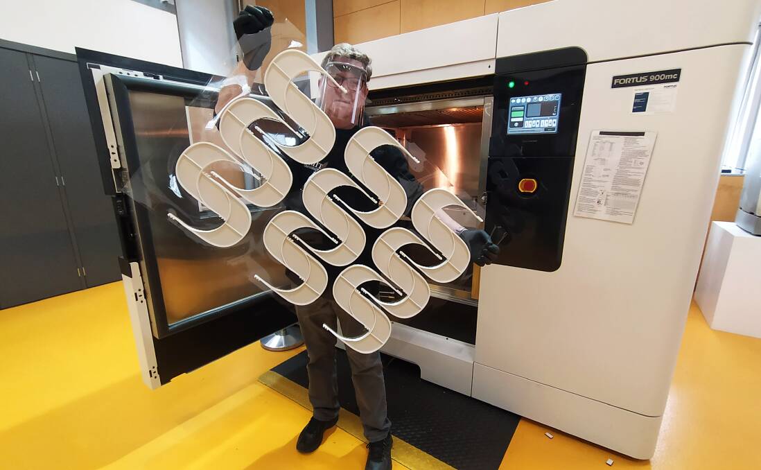 PROTECTION: RMIT's Paul Spithill with a batch of 3D printed plastic face shield frames at their Advanced Manufacturing Precinct. Picture: Supplied.