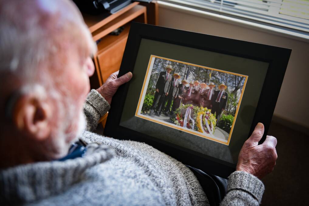 Geoff Chapman looking at a photo of the eight men who got to revisit Borneo. Picture: Paul Scambler