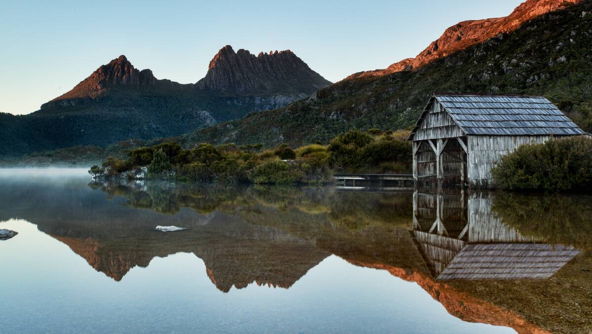 The glassy lake of Cradle Mountain reflects the magical scenery behind it.