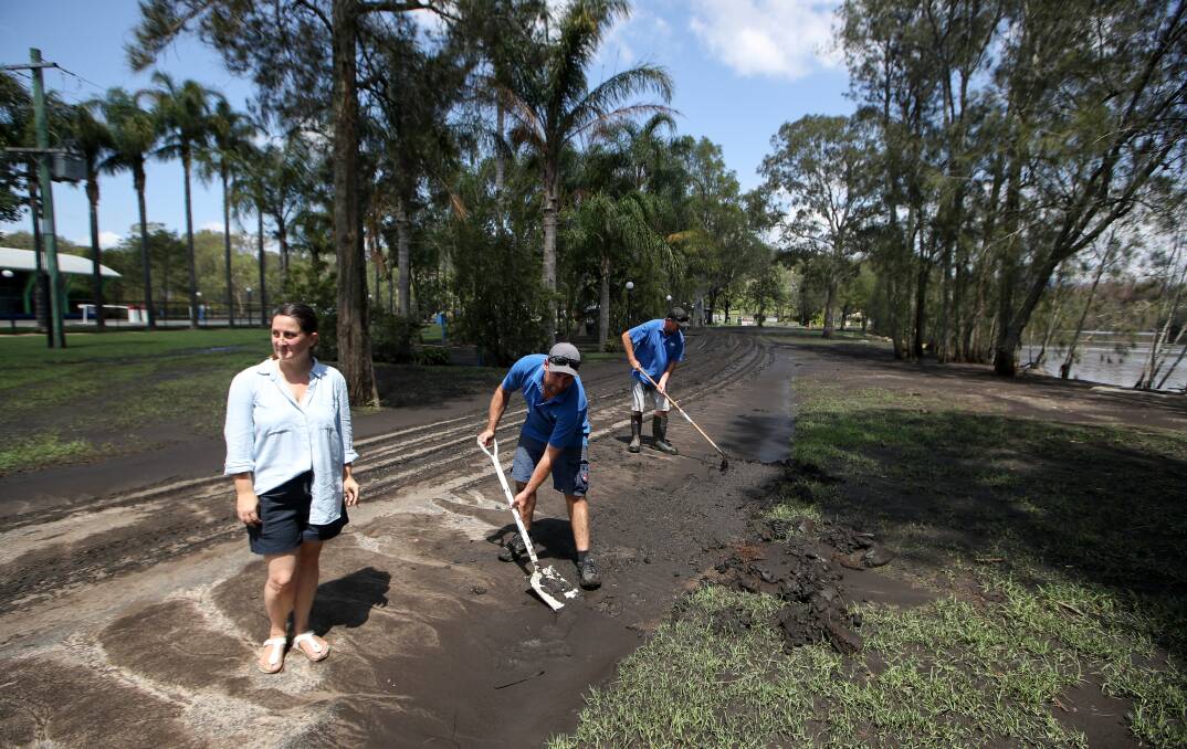 MUDBATH: Jaclyn Geurin, Pete Graham and Tod Sutherland clean up the Big4 Nelligen Holiday Park after the flood. Photo: Adam McLean
