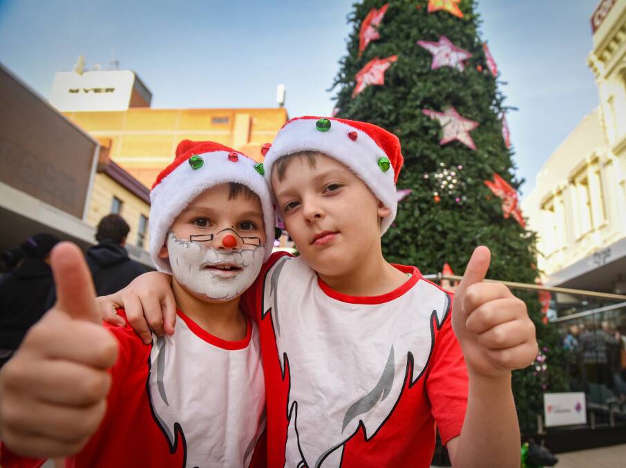 TWINS: Nine-year-olds Riley and Cooper Howe give the thumbs up for Launceston's Christmas tree on Brisbane Street Mall on Friday. Picture: Paul Scambler.