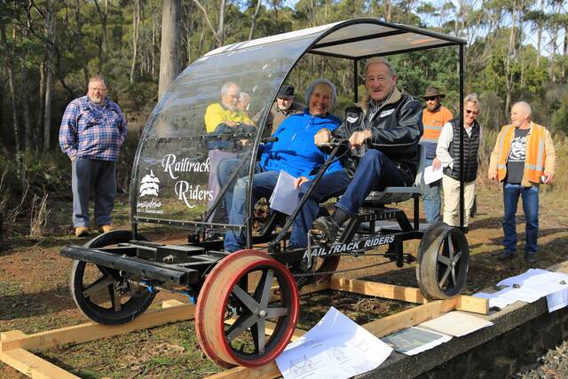 NEW VENTURE: Wendy McLennan and Independent Windermere MLC Ivan Dean with volunteers and concept plans drawn by architect Lez Penzes. The rail track rider was on loan from an identical venture in the state's South in Maydena. Picture: Roger McLennan.