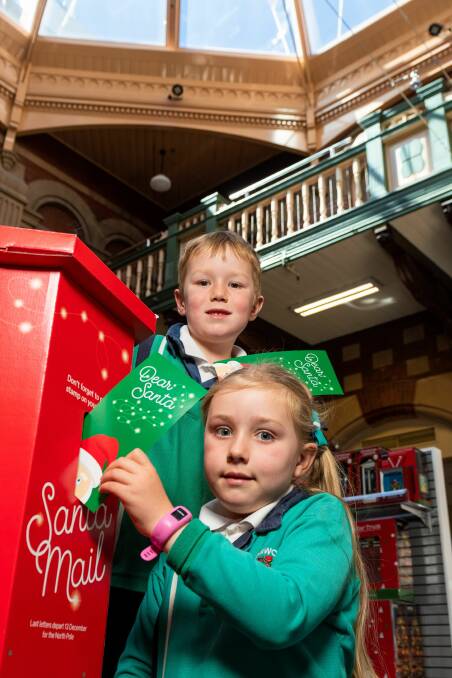 CHRISTMAS IS HERE: Olivia and Thomas Simmons post their letters to Santa at the Launceston Post Office. Picture: Phillip Biggs.