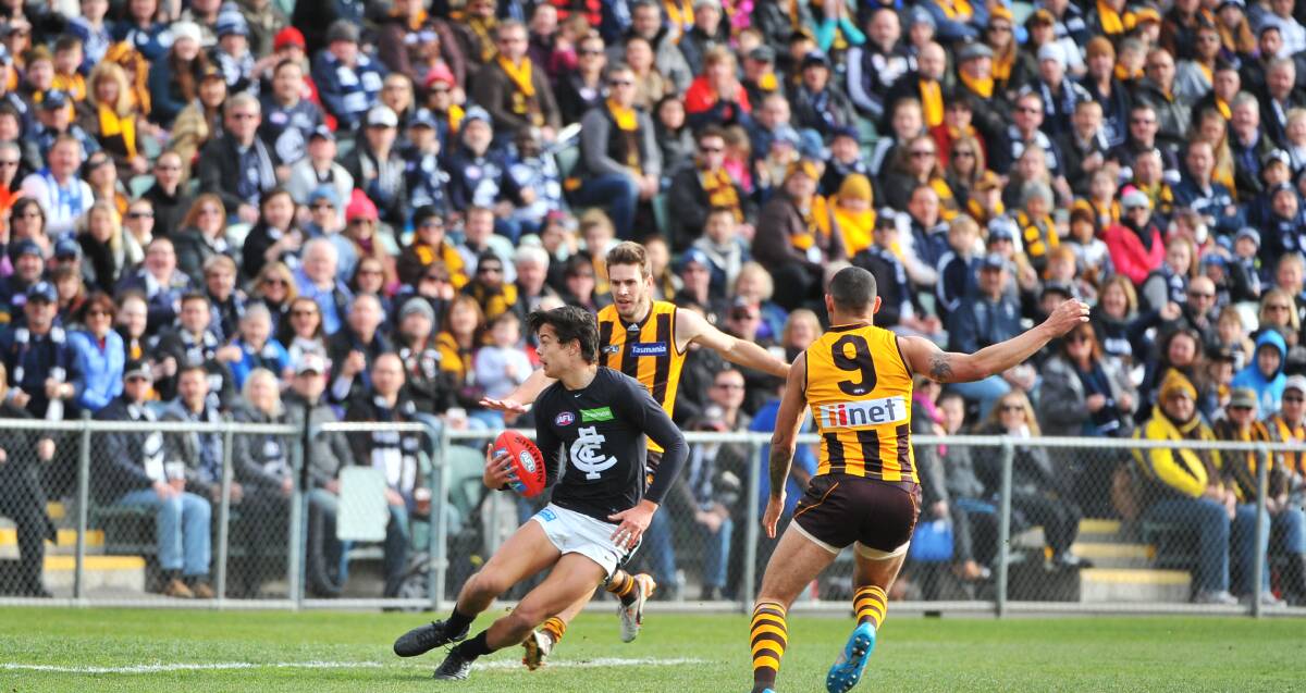Under Pressure: Carlton's Jack Silvagni gathers possession from Hawk Grant Birchall as a packed crowd watches from the stands at Aurora Stadium. Picture: Scott Gelston