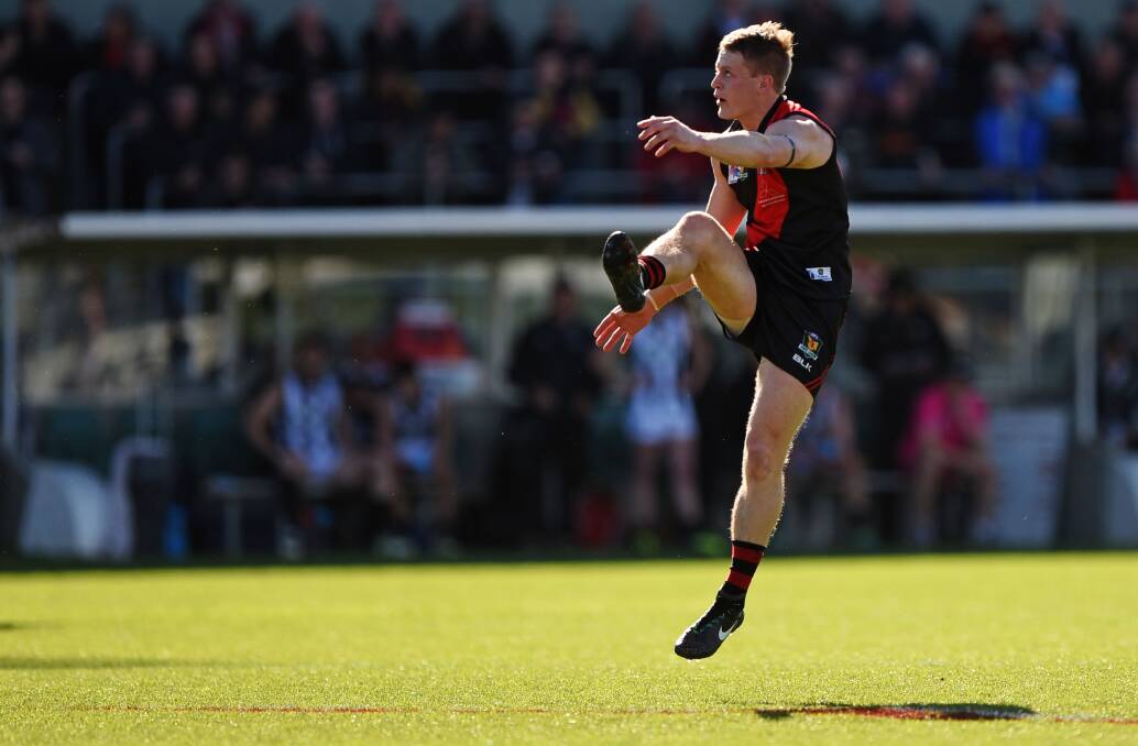 ELEVATED: The Bombers' Mark Walsh gets some air as he kicks for goal during the first half.