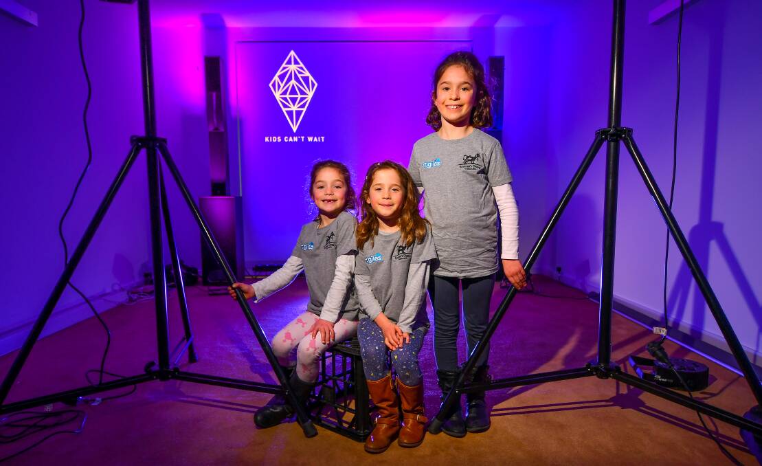 Blue: Twins Lucy and Annie, 5, and their seven-year-old sister Emma Barnett check out the lighting setup for the Blue Diamond dinner. Picture: Scott Gelston
