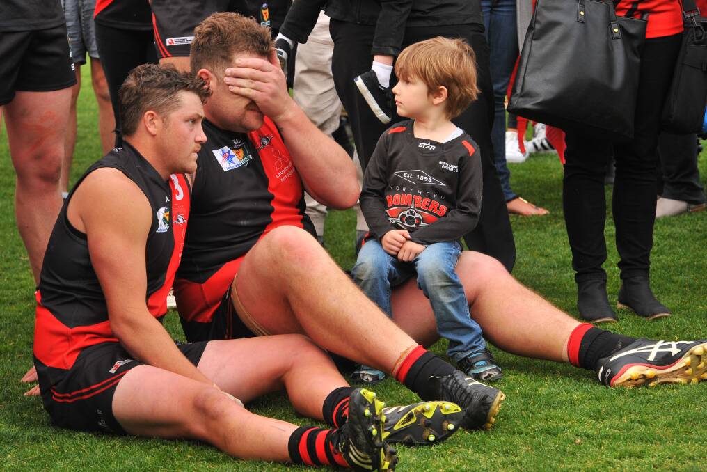 DEFEAT: North's Zac Burt and Daniel Roozendaal take in the loss as Roozendaal's three-year-old son Max sits on his father's knee. 