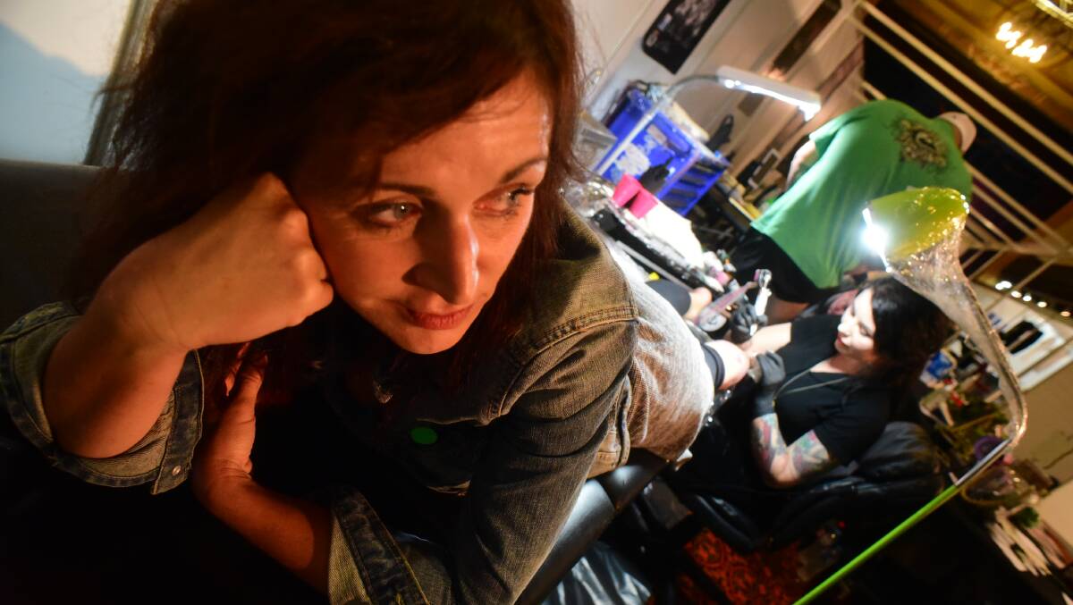 Kelly Roberts, of Launceston, gets some work done by Hobart tattoo artist Hannah Flowers. Picture: Paul Scambler