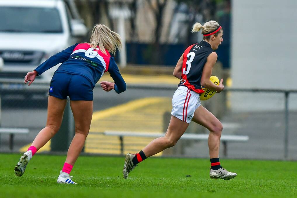 Bounding: Former Launceston player Jodie Clifford escapes Blues tall Abbey Green in a strong performance for the Bombers.