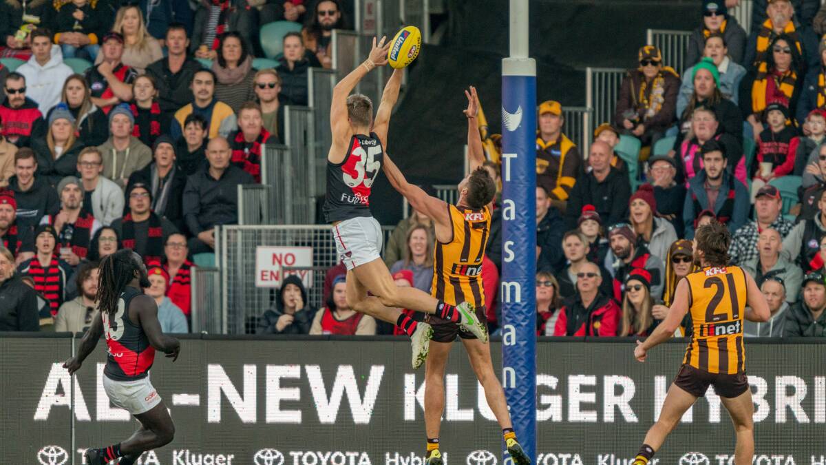 PACKED: Essendon's Matt Guelfi and Hawthorn's Daniel Howe battle when the two sides met at UTAS Stadium. Picture: Phillip Biggs.
