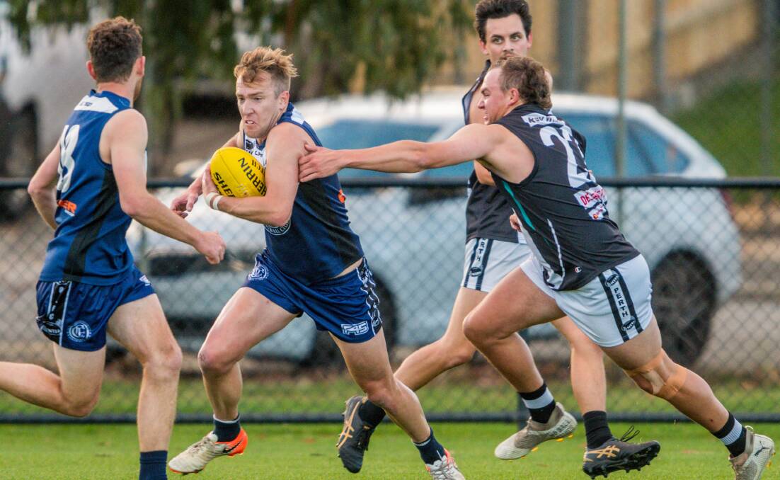 Get away: Old Launcestonians' Richard Howe tucks the ball under his arm and leaves his Perth opponent. The key Blue returns this week. Picture: Phillip Biggs