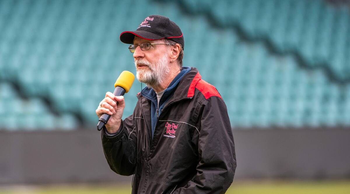 Boundary announcer Tony Webb speaks back to his crew in the box. Picture: Paul Scambler