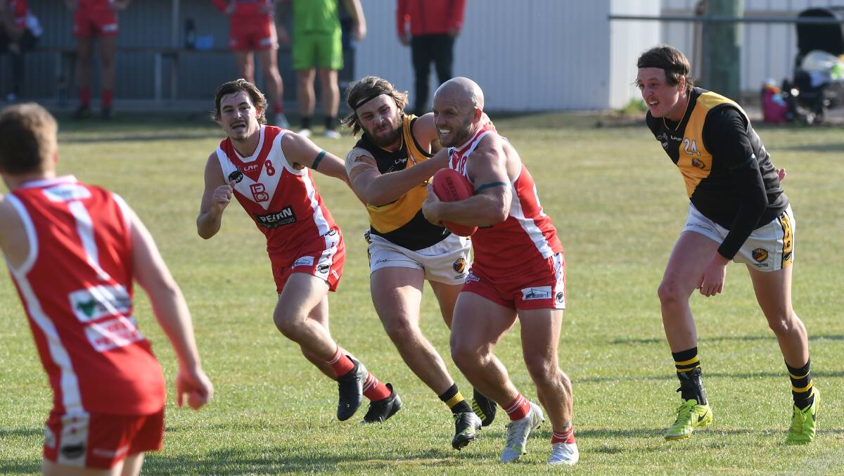 Cop that: Josh Holland tucks the ball under his arm and runs on with it. Picture: Paul Scambler