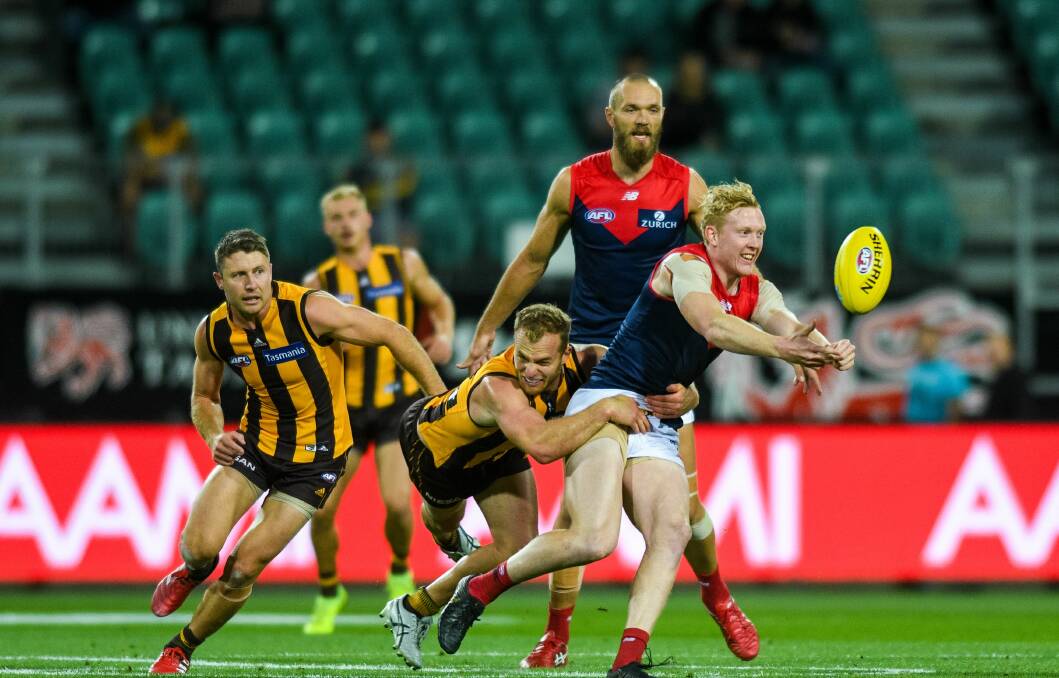 DEE-LIGHTFUL: Clayton Oliver handballs while Norm Smith Medal favourite Max Gawn looks on at UTAS Stadium in last year's pre-season. Picture: Phillip Biggs