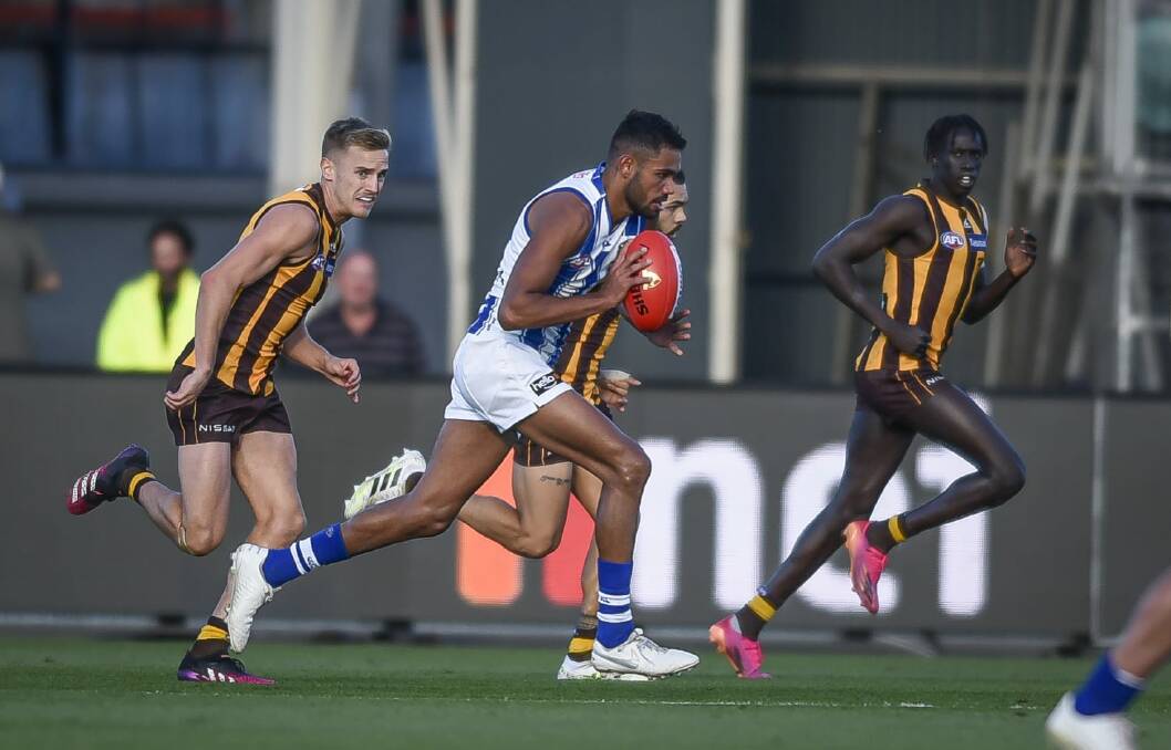 Full flight: North Melbourne's Tarryn Thomas streams through the middle of UTAS Stadium surrounded by Hawks. Picture: Craig George