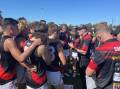 North Launceston listen to new coach Adrian Smith at quarter-time. Picture by Josh Partridge