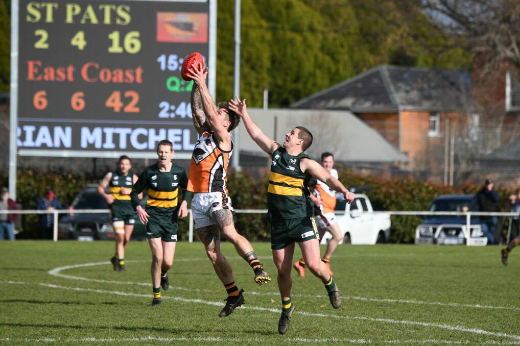 Leaping: East Coast's Nick Denholm marks in front of St Pats opponent Joey Taylor as the Swans kicked off the finals with a nail-biting win. Picture: Paul Scambler