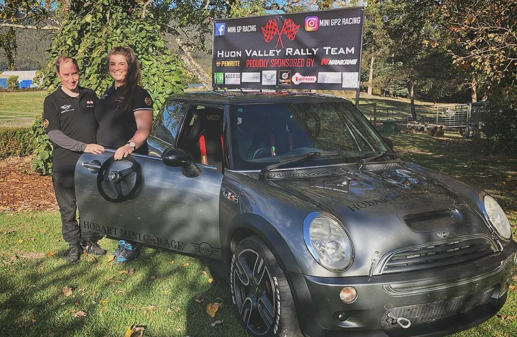 The couple with their Targa Tasmania entry and the Huon Valley Rally Team banner.