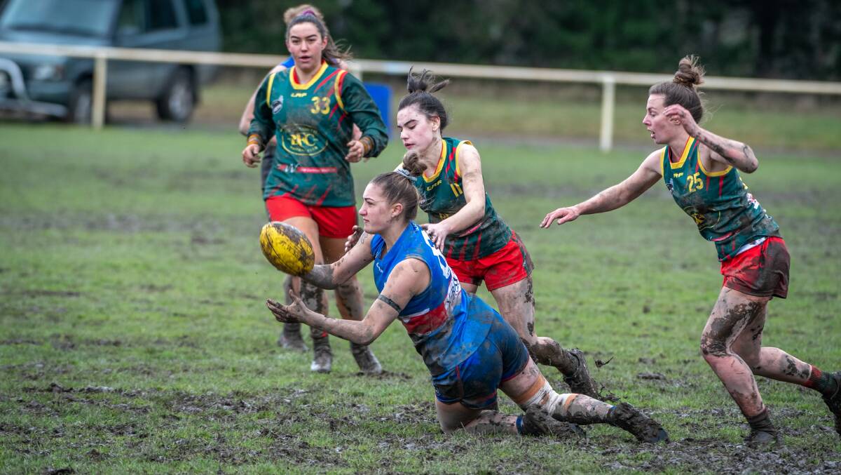 Covered in mud: South Launceston's Morgan Carlson gets a handball out. Pictures: Paul Scambler