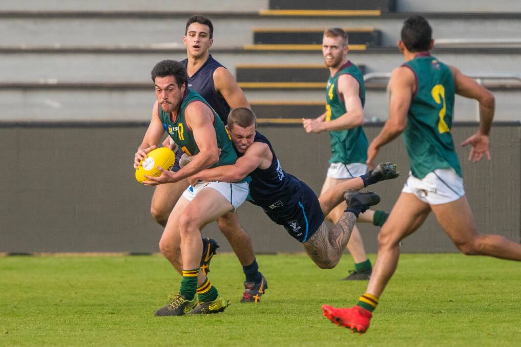 Shrugged off: Phillip Bellchambers looks to release both his opponent, Tom Simpson, and the ball to three-goal superstar Alex Saunders. Picture: Phillip Biggs.