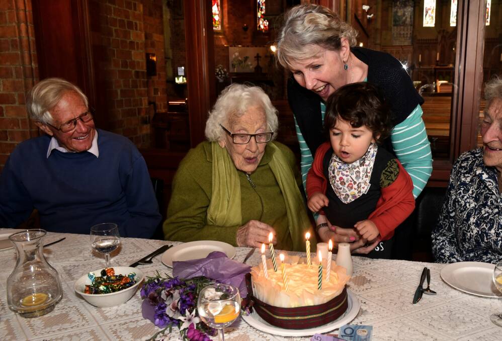 BIRTHDAY: Marjorie Fitzpatrick marks her 102nd birthday at Holy Trinity Church, where Arden Regmi-Webb held by Sue Webb helped blow out the candles. 