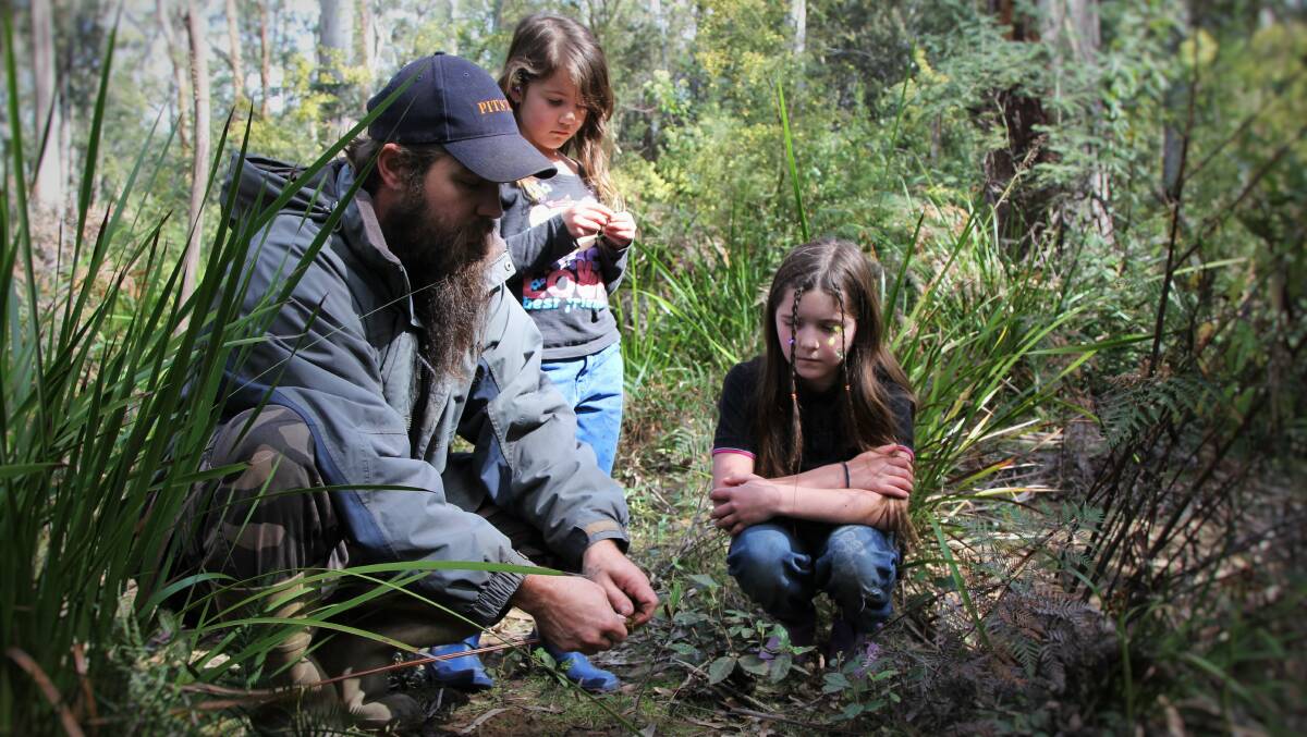DISCOVERING: Damien Compton teaching his daughters Evelyn and Shayla about foraging. Pictures: Piia Wirsu