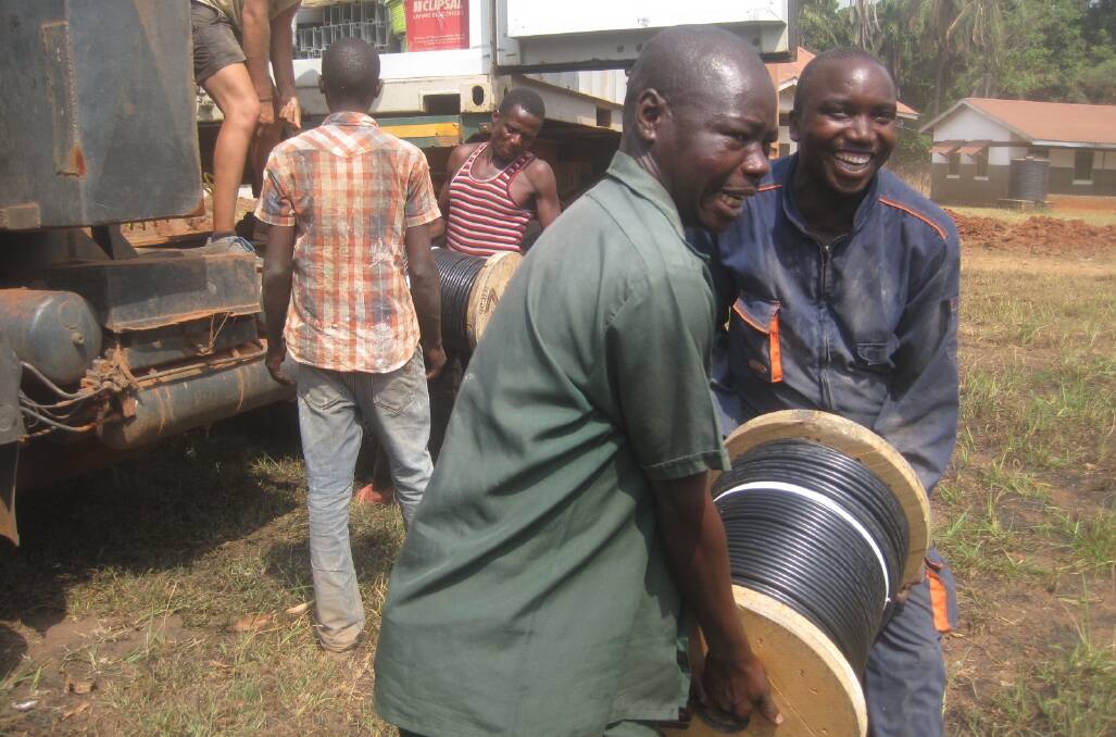 Locals helping unload all the equipment needed to install the system in Nzara, South Sudan.