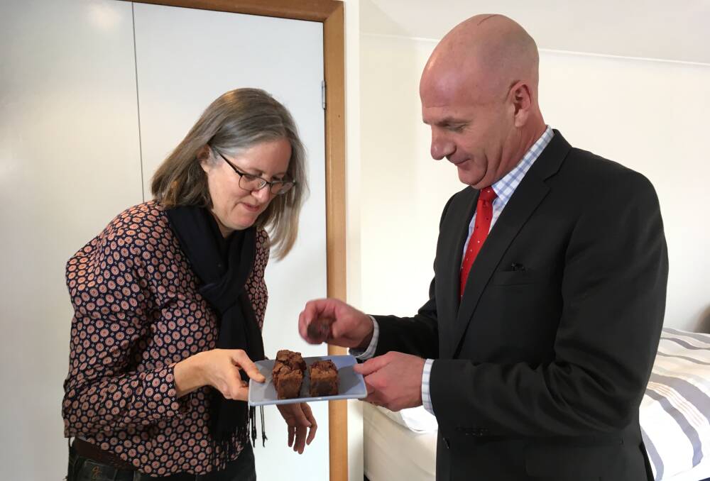 AirBnB "superhost" Elizabeth Poland shares one of her infamous brownies with Treasurer Peter Gutwein. Picture: Holly Monery