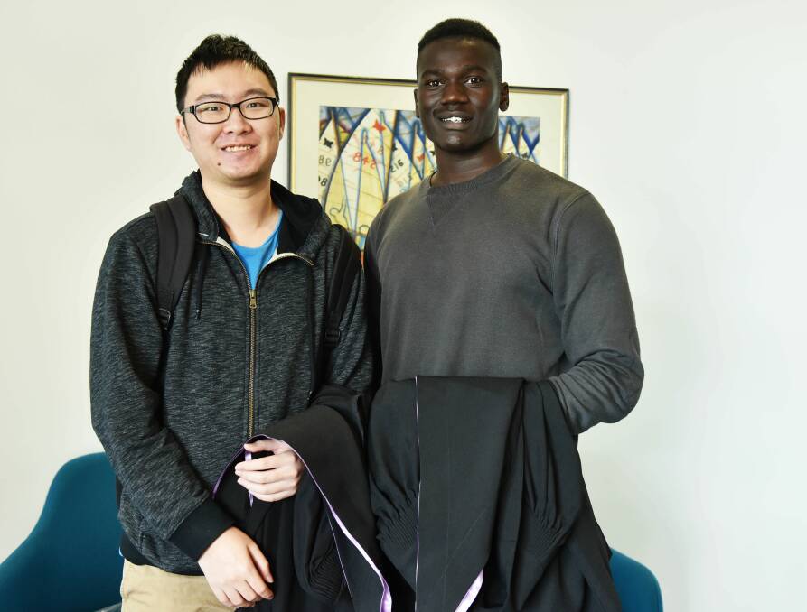 GRADUATION READY: UTAS Biomedical Science graduates Shawn Tan and Samora Koko pick up their gowns for Saturday's ceremony. Picture: Scott Gelston.