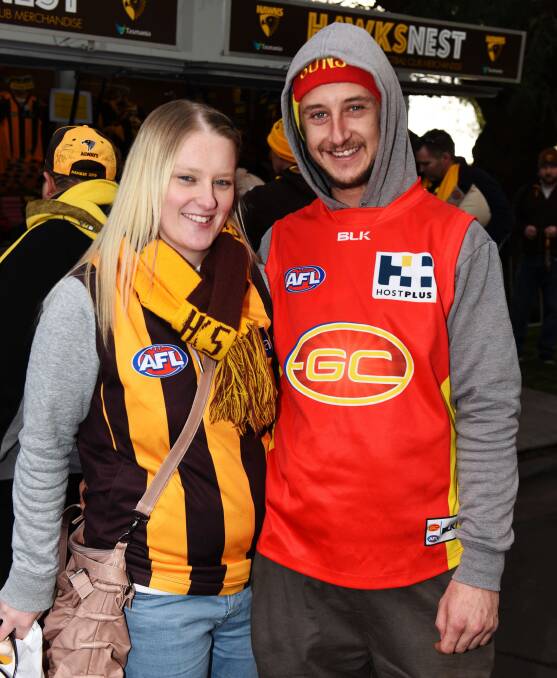 OPPOSING FORCES: Aleisha Bonney and Sam Jarman of Devonport cheered on different teams at Sunday's AFL games. Mr Jarman supports Gold Coast for his son Riley.