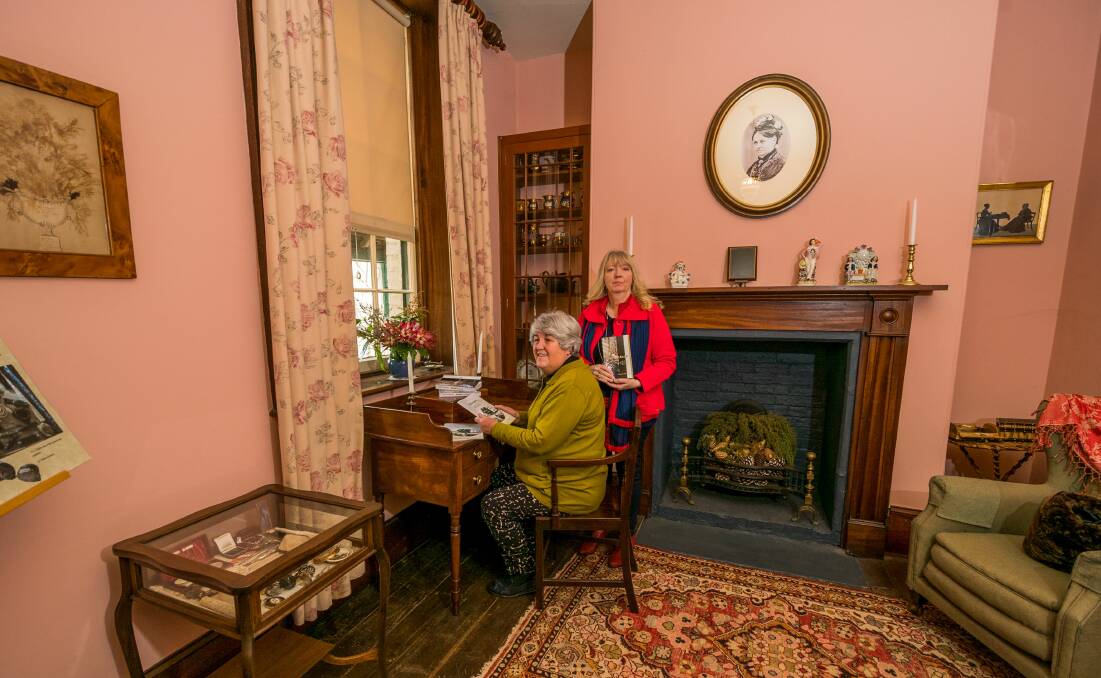 LIVING HISTORY: Lucille Gee and Sue Harrison beneath of portrait of Franklin House's original writer, Charlotte Hawkes. Picture: Phillip Biggs
