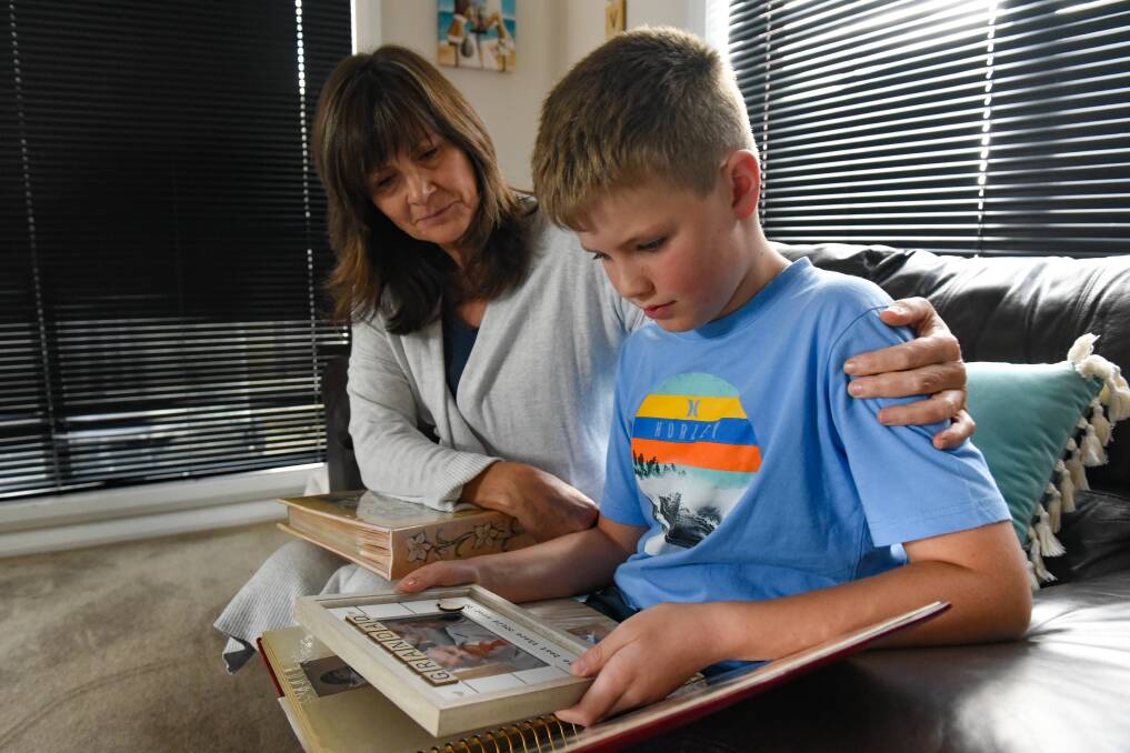 TREASURED MEMORIES: Shelley Clay with her son, Joshua Clay, 8, look over a photograph of her father. Picture: Paul Scambler
