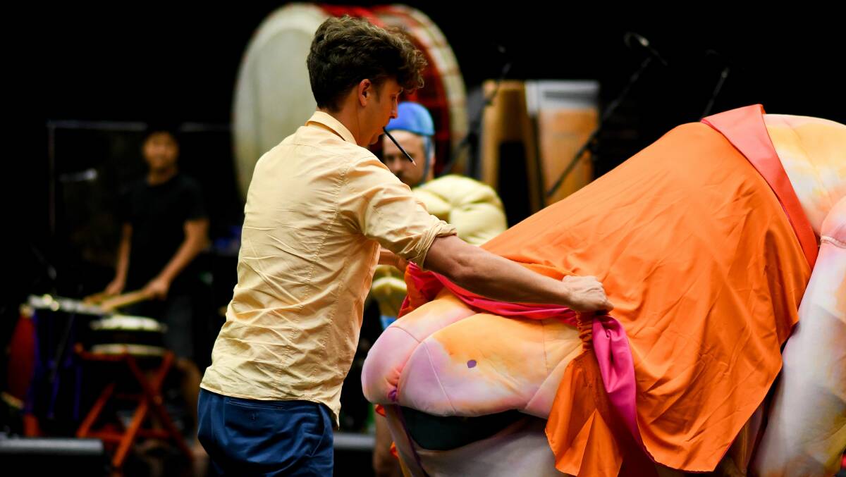 Director Sam Routledge makes an adjustment to the backside of one of the Ubu puppets.