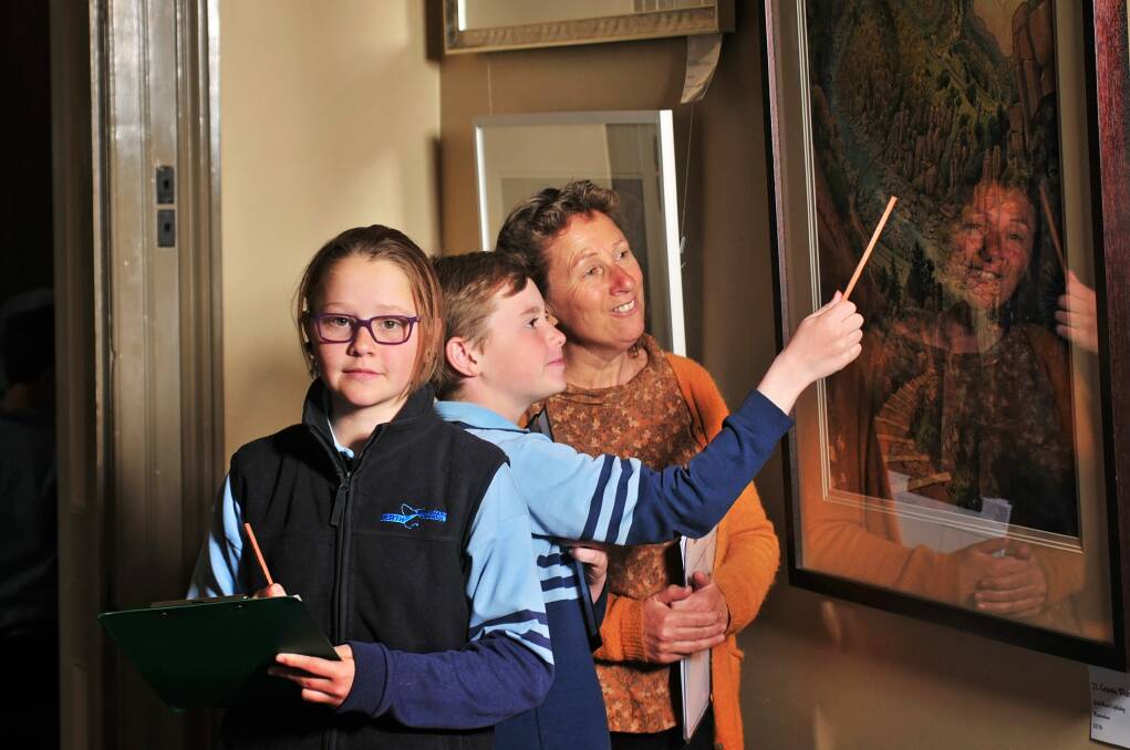 ART: LAS artist Claire Holder discusses a painting by Graeme Whittle with Perth Primary School pupils Jennifer Areynolds and Jack Triffett, at the 2018 Esk Award opening. Picture: Phillip Biggs