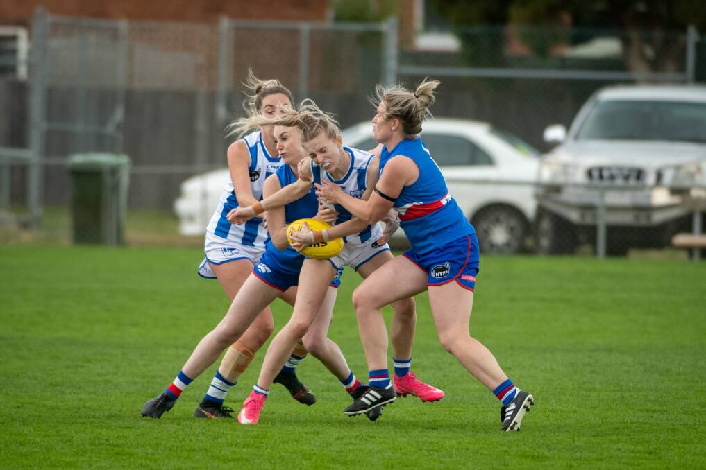 OUTNUMBERED: South Launceston duo Izabella Ann Duniam and Hannah Viney take down Deloraine's Lily James in a Bulldog sandwich. Picture: Paul Scambler
