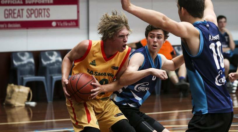 FIGHTING FOR SPACE: Cocker in action for Tasmania at the under-18 national championships. Picture: Fairfax Media 