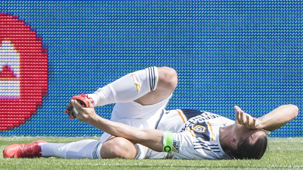 OH THE PAIN OF IT: Retired Swedish striker and L.A. Galaxy recruit Zlatan Ibrahimovic lies on the ground after slapping an MLS opponent who trod on his toe. Picture: AP